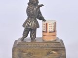 bronze figurine of a boy holding a cup on a wooden stand