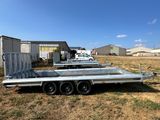 a flatbed trailer parked in a field next to a building