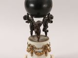 an image of a statue of a man holding a black ball on top of a pedestal
