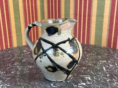 PICHET en grès vernissé. Porte une signature au revers.