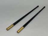 a pair of black and gold chopsticks sitting on top of a white table