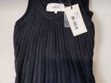 Le pull est exposé sur la table, avec une étiquette de prix