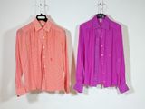 pair of pink and orange shirts hanging on a white wall