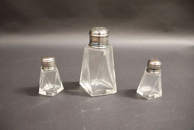 three salt and pepper shakers sitting on a table