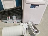 a white air conditioner and a white box on the floor