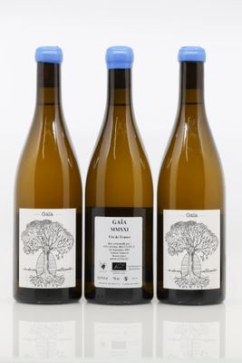 trois bouteilles de vin posées les unes à côté des autres sur une surface blanche