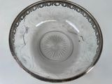 a glass bowl with a silver rim on a white table