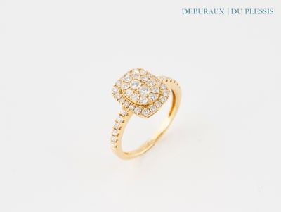 une bague en or jaune ornée d'un diamant en forme de poire en son centre