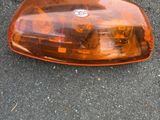 un feu arrière de voiture posé par terre à côté d'une paire de chaussures