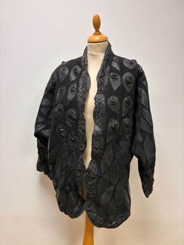 ANONYME - Manteau noir en laine, décor en cuir. Taille 40 à vue