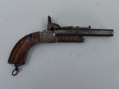 un vieux pistolet avec une poignée en bois sur une surface blanche