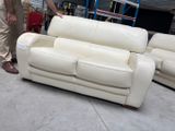 a man standing next to two couches in a warehouse