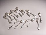 a lot of silver spoons and forks laid out on a table