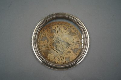 Dessous de bouteille cerclé d'argent.