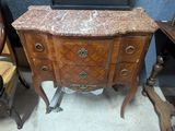 a marble top dresser with a laptop on top of it