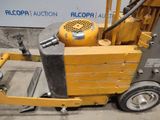 a small yellow machine that is sitting on the ground
