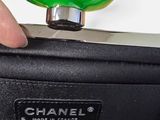 chanel green handle on a black bag with a hand holding it