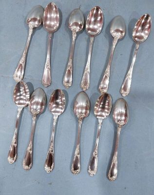 six cuillères en argent sont disposées en rangée sur un fond bleu