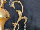 a gold colored chandelier with crystal decorations on top of it