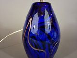 une lampe en verre bleu posée sur une table