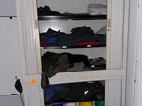 une armoire haute sur laquelle sont posées de nombreuses paires de chaussures