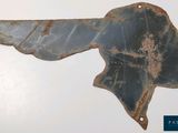 an old rusty piece of metal with a bird on it