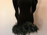 une photo d'un mannequin portant une jupe en plumes, posé sur un socle