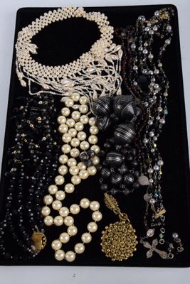 a close up of a tray with a bunch of jewelry on it