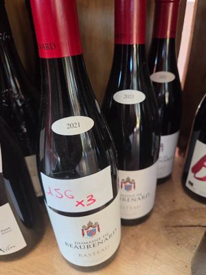 several bottles of red wine are lined up on a shelf