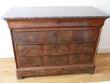 a wooden dresser with a marble top on a hard wood floor