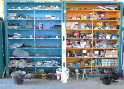 a blue cabinet filled with assorted items in a garage