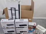 Plusieurs cartons contenant des appareils électroniques sont posés par terre.