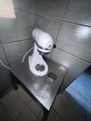 un mixeur blanc posé sur une table en métal