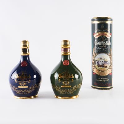 trois types différents de bouteilles d'alcool sont alignées sur une surface blanche