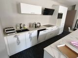 an image of a kitchen with white cabinets and a marble counter top