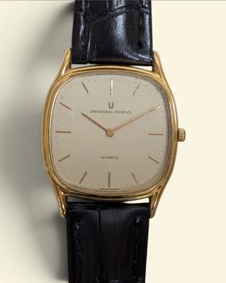 a close up of a gold watch with a black strap