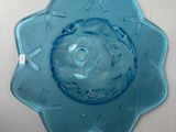 a blue flower shaped glass bowl on a white table