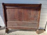 a wooden bed with a wooden head board on it
