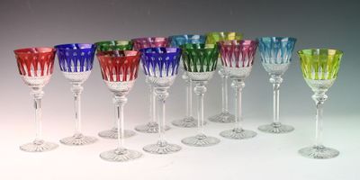 many different colored wine glasses lined up in a row