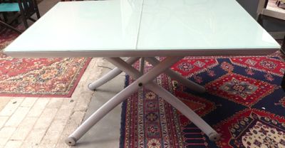 une table blanche avec un plateau bleu posée sur un tapis