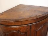 a wooden corner cabinet with a door and a drawer
