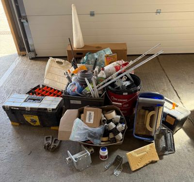 a pile of junk in a garage next to a garage door