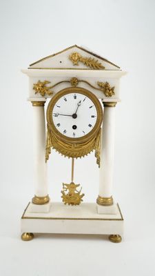 une horloge blanche et or posée sur une table