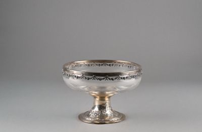 an antique silver footed bowl on a pedestal on a gray background