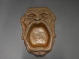 une image représentant une sculpture de singe la bouche ouverte