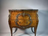 une petite commode ornée d'un motif décoratif sur la façade