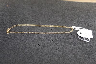 a white necklace with a white tag on it sitting on a black surface