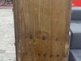 a tall wooden cabinet sitting on a rug on the floor