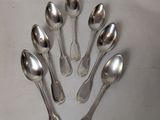 six spoons arranged in a circle on top of a table
