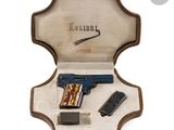 a wooden case with a gun and a magazine inside of it